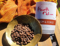 Gold bowl with coffee beans and 'Hearth Medium' coffee package on a wooden surface